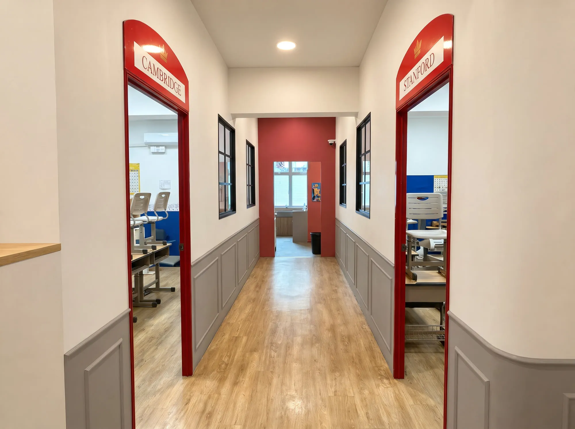 The corridor at the TITAN Taman Molek campus, with red archways into the Cambridge and Stanford classrooms